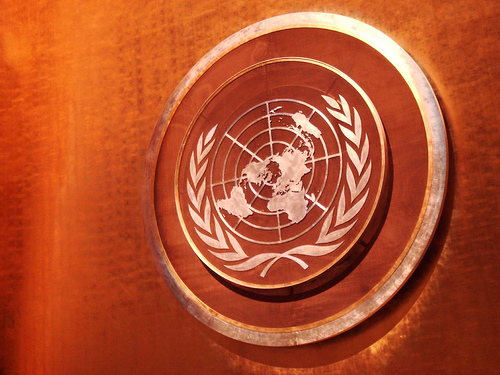 Embossed United Nations symbol engraved or etched on white on a copper colored plaque,