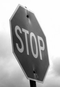 black and white image of a stop sign at an angle