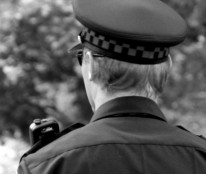 black and white head and shoulders photo of uniformed officer from behind